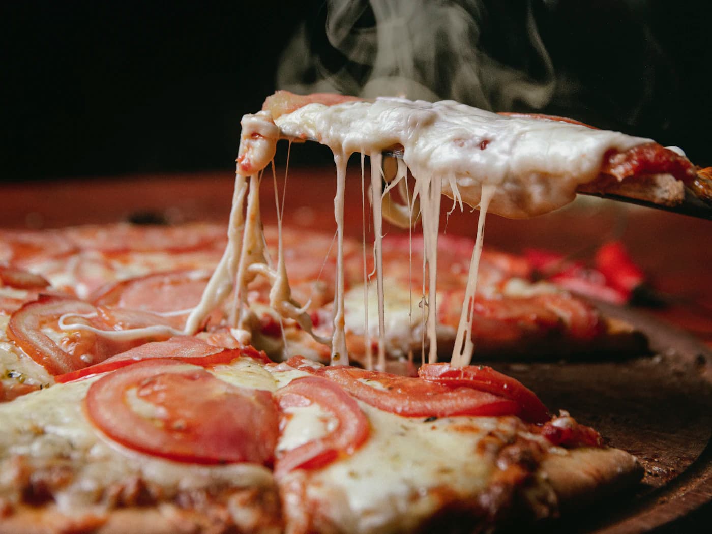 Gorąca pizza z pomidorami i ciągnącym się serem