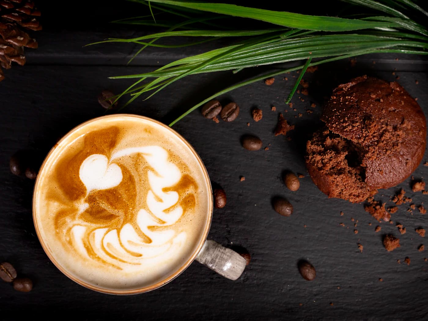 Cappuccino z latte art i czekoladowe ciastko
