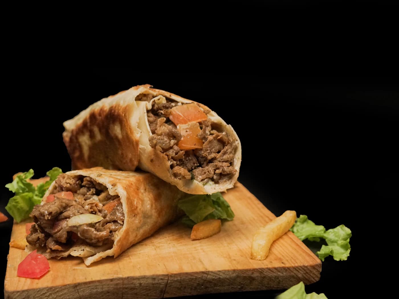 Kebab rollo przekrojony na pół na drewnianej desce